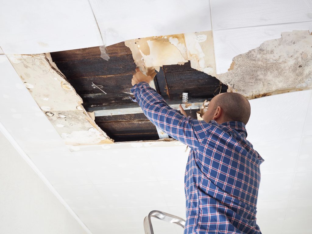maintenance reviewing ceiling damage in strata builiding